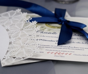Faire-part de mariage en dentelle découpée au laser avec ruban bleu marine et carte crème