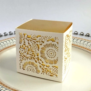 Close-up of laser-cut hollow rose patterns on white wedding candy gift box