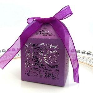 Détail d'une boîte à bonbons violette découpée au laser avec motifs floraux et ruban soie
