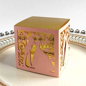 Detail of laser-cut wedding favor box with pink paper and inner gold foil lining