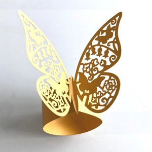 Detailed close-up of golden butterfly laser-cut paper napkin ring with intricate patterns
