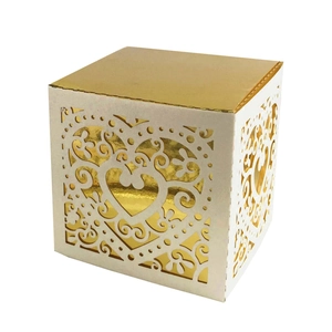 Macro view of laser-cut heart patterns on white gift box with gold interior lining