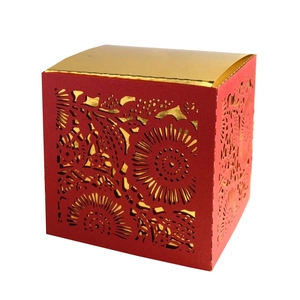 Macro detail of laser-cut rose patterns on a square red and gold gift candy box