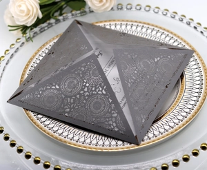 Laser-cut silver wedding invitation card with floral patterns on a decorative plate