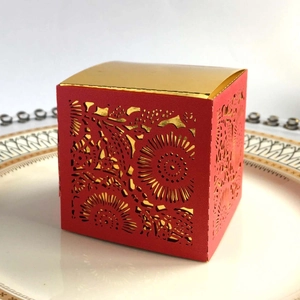 Detail of red laser-cut floral wedding candy box with a luxurious gold interior finish