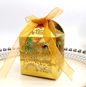 Détail du motif floral découpé au laser sur boîte dorée avec ruban pour mariage