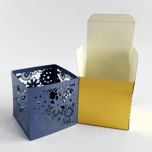 Laser-cut floral gift box featuring navy blue outer sleeve and golden inner lining