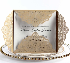 Detail of laser-cut lace mandala wedding invitation on an elegant porcelain plate