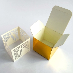 Detail showing laser-cut wedding favor box with hollow heart and gold inner container
