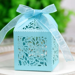 Light blue laser-cut floral wedding favor box with a delicate matching organza ribbon