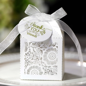Détail de motif floral découpé au laser sur boîte de mariage blanche avec ruban