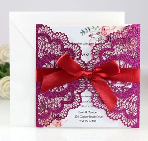 Detail of laser-cut purple glitter invitation with red ribbon and floral inner card