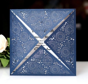 Macro detail of navy blue laser-cut mandala wedding invitation with elegant white insert card