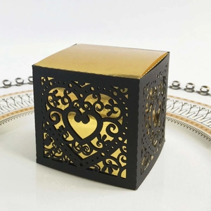 Detail of black laser-cut gift box with hollow heart pattern and gold foil inner lining