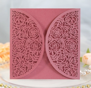 Intricate laser-cut rose patterns on elegant deep red wedding invitation card