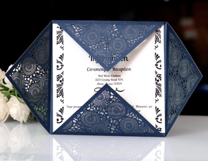 Detail of navy blue laser-cut invitation with intricate lace pattern and white inner card