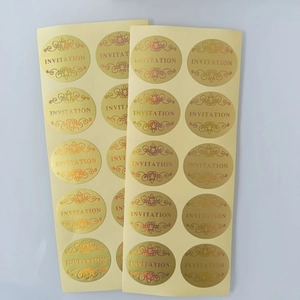 Close-up of golden embossed round invitation seals with elegant patterns and text