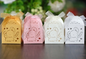 Detailed laser-cut elephant and heart patterns on wedding favor boxes with ribbon