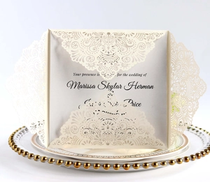 Detailed laser cut off-white wedding invitation with intricate mandala lace pattern