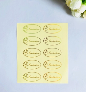 Detail showing oval gold Invitation stickers with heart design for wedding envelopes