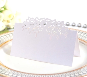 Detailed laser-cut heart pattern on white wedding table place card in elegant setting