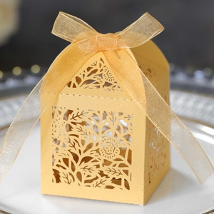 Detailed laser-cut gold hollow gift box with floral patterns and a matching ribbon bow