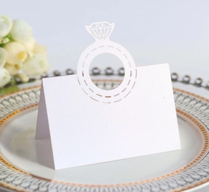 Laser cut white diamond ring place card on an elegant dinner plate for wedding table decor