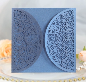 Detail of laser-cut rose patterns on dark blue pearlescent wedding invitation cover
