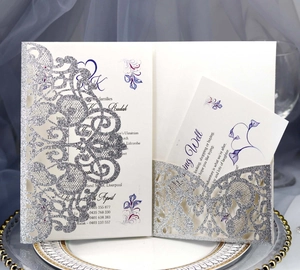 Detail of laser-cut silver glitter wedding invitation with purple floral insert cards