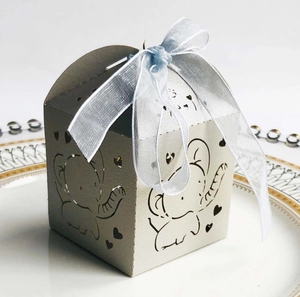 Detail of laser-cut silver candy box featuring elephant heart motifs and blue organza ribbon
