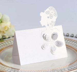 Detail of laser-cut wedding place card with 3D paper flower and pearl white texture
