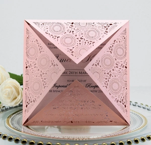 Detailed laser-cut pink wedding invitation with floral patterns and pearl paper texture