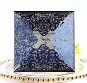 Détails de faire-part de mariage découpés au laser bleu marine et bleu clair sur une assiette