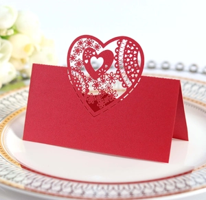 Elegant laser-cut red heart wedding place card with intricate lace patterns for table decor