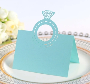 Detail of light blue laser-cut place card with diamond ring design on white porcelain plate