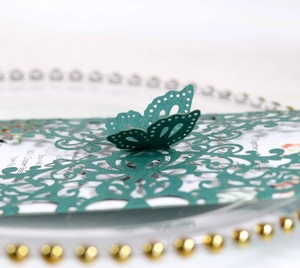 Detailed laser cut lace wedding invitation with a 3D butterfly on dark green cardstock