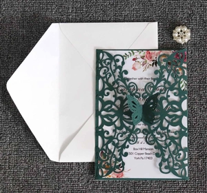 Detail of laser-cut butterfly wedding invitation with inner page and pearl accessory