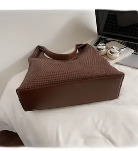 Large dark brown woven tote bag with smooth leather straps shown with office work essentials