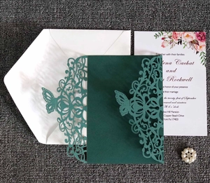 Detail of laser-cut dark green butterfly wedding invitation with floral insert card