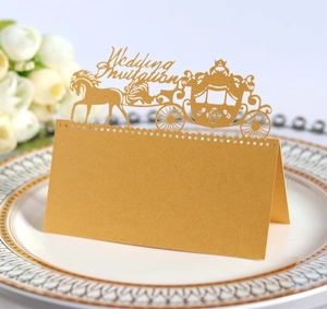 Detailed laser-cut gold pumpkin carriage wedding place card on a decorative plate