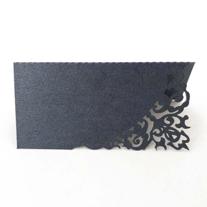 Intricate laser-cut floral pattern on green paper card for elegant wedding table seating