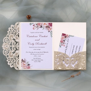 Detail of laser-cut ivory floral wedding invitation with champagne gold glitter insert