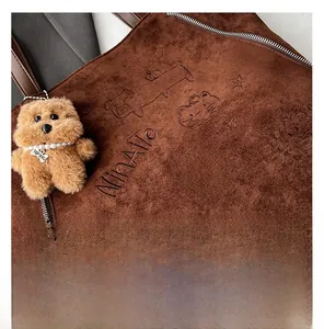 Détail du sac cabas en daim marron avec gaufrage Nina Alle et charm ourson en peluche