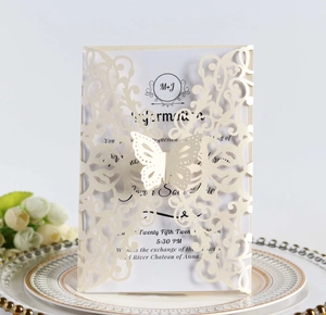 Macro detail of laser-cut butterfly wedding invitation with elegant ribbon on ornate plate