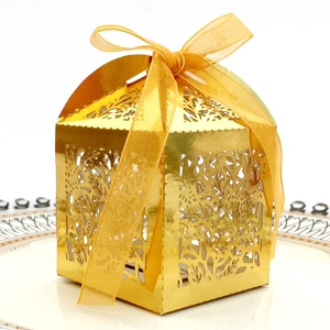 Detailed laser cut gold wedding favor box with intricate branch pattern and organza ribbon