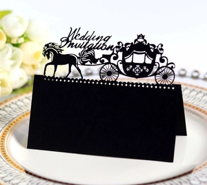 Detailed laser-cut black wedding invitation card with elegant carriage design on white porcelain
