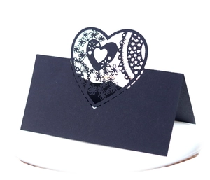 Black laser-cut heart place card with intricate floral lace patterns for wedding tables