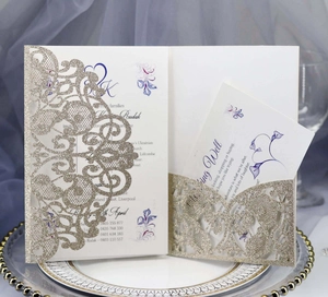 Detail of laser cut gold glitter wedding invitation set with floral inner cards on a plate