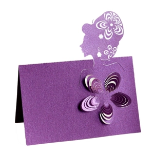 Macro shot of purple laser-cut wedding place card with 3D floral accent and silhouette