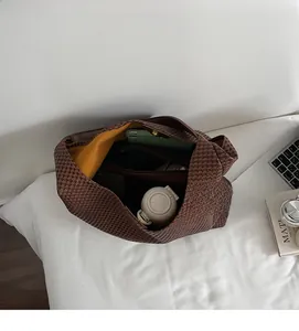 Top view of large brown woven tote bag interior with yellow lining and functional space